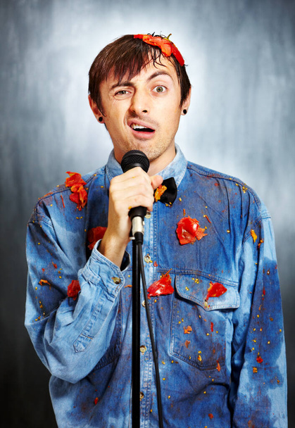 Seriously unfunny. Portrait of an unsuccessful standup comedian covered in rotten tomatoes. - Photo, Image