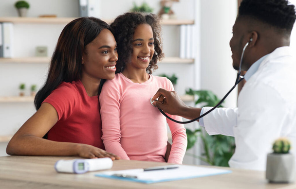 Smiling african american girl visiting doctor at clinic - Photo, Image