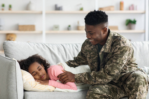 Черный солдат разбудил свою дочь и вернулся домой. - Фото, изображение