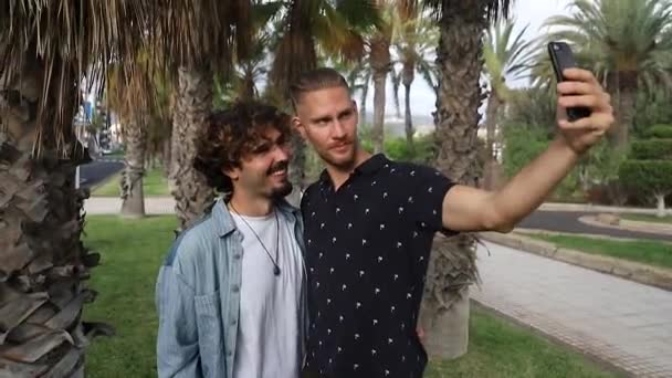 Homoseksüel çift selfie çeker. Mutlu iki eşcinsel birbirini seviyor ve akıllı telefonla fotoğraf çekiyor. - Video, Çekim
