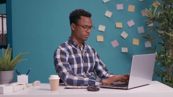 Άνδρας γραμματέας απαντά σταθερό τηλέφωνο στο γραφείο με φορητό υπολογιστή - Πλάνα, βίντεο