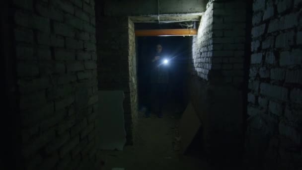 ein Mädchen in einem schrecklichen Zustand sucht in einem beängstigenden Keller nach einem möglichen Unterschlupf für den Fall einer Bombenexplosion. Nachrichten über die Spannungen zwischen der Ukraine und Russland. Russische Aggression. Kriegsgefahr. - Filmmaterial, Video