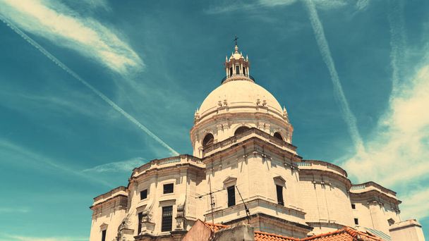 A wide-angle view from the bottom of The Church of Santa Engracia or another name National Pantheon on a very sunny day, with blue sky with clouds and aircraft contrails behind the building - Foto, immagini