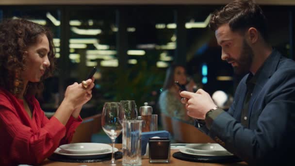 Digitales Paar surft beim Abendessen im Restaurant. Social Media-Konzept. - Filmmaterial, Video