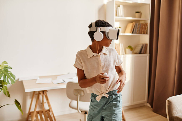 Αφρο-Αμερικανός έφηβος παίζει immersive παιχνίδι VR - Φωτογραφία, εικόνα