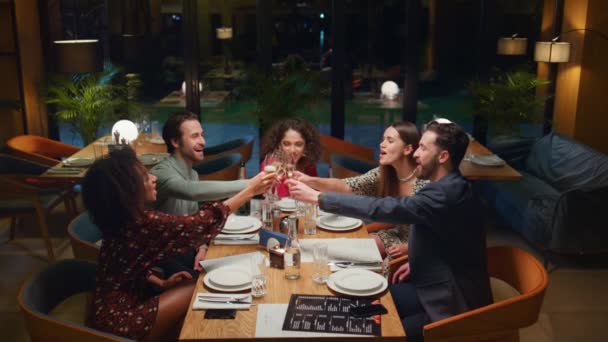 Szczęśliwi przyjaciele imprezują pijąc w restauracji. Wielu ludzi wznosi tosty.. - Materiał filmowy, wideo