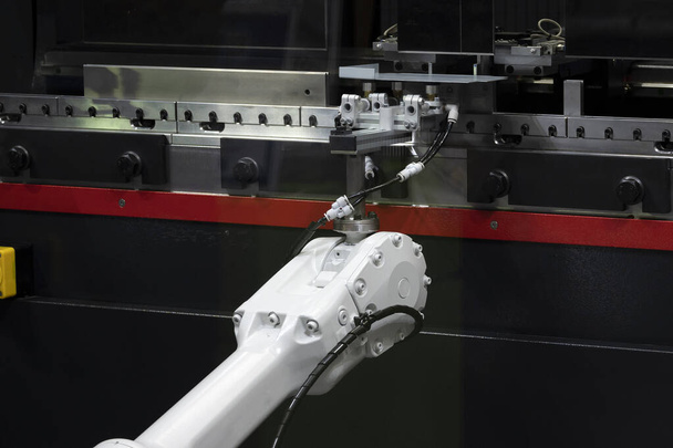 Yüksek teknoloji levha metali, hidrolik bükme makinesiyle çalışan robotik kolla çalışıyor. Metal levha işleme sisteminde robotik sistem tarafından sanayi 4.0 üretim kavramı. - Fotoğraf, Görsel