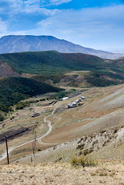 vista panorâmica da estrada de terra e fazendas em um desfiladeiro de montanha - Foto, Imagem