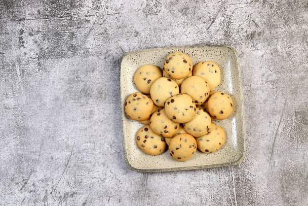 Homemade chocolate chip cookies on a square  plate on a dark background. Top view, flat lay - Photo, Image