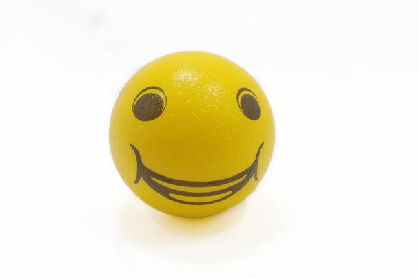 Bola sonriente amarilla aislada en el fondo blanco - Foto, imagen