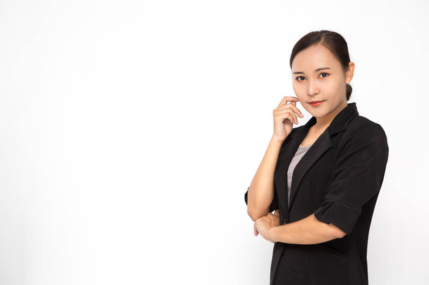 Krásná asijská obchodní žena v černém obleku se zkříženými pažemi na bílém pozadí a kopírovat prostor. Sebevědomá asijská pracující žena s úsměvem a veselý - Fotografie, Obrázek