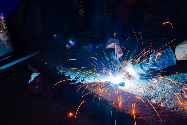 Industrial workers at a close-up welding plant - 写真・画像