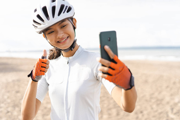 mulher asiática ciclista tirar selfie usando telefone inteligente - Foto, Imagem