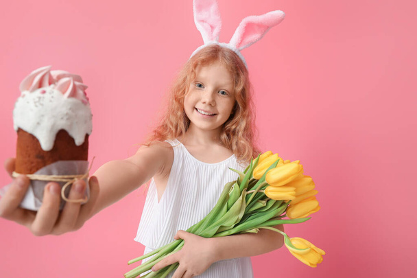Menina bonito com orelhas de coelho, flores e bolo de Páscoa no fundo rosa - Foto, Imagem