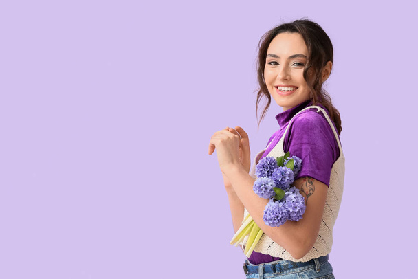 Красивая девушка с гиацинтовыми цветами на цветном фоне - Фото, изображение