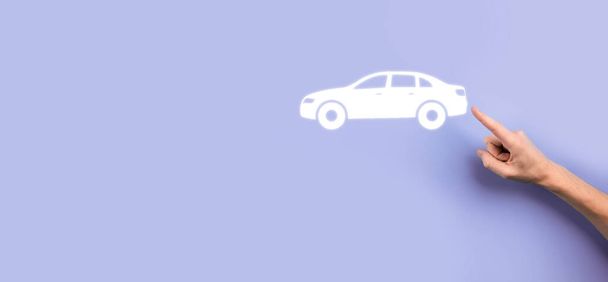 Männliche Hand hält Auto-Ikone auf grauem Hintergrund. Breite Banner Zusammensetzung. Kfz-Versicherungen und Kollisionsschadensersatzkonzepte. - Foto, Bild