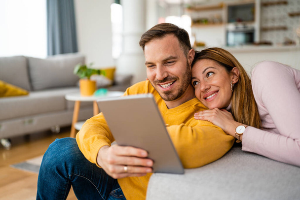 Young couple in love at home enjoying together, using tablet - Foto, Imagen