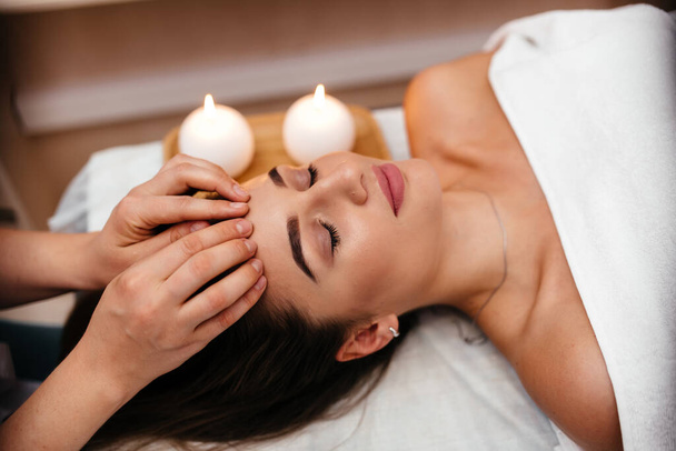 Spa. Woman enjoying anti-aging facial massage - Foto, imagen