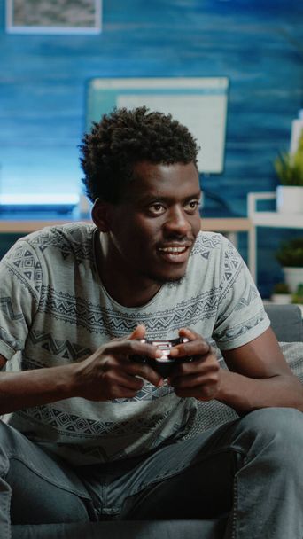 Happy man playing video games with controller on console - Photo, Image