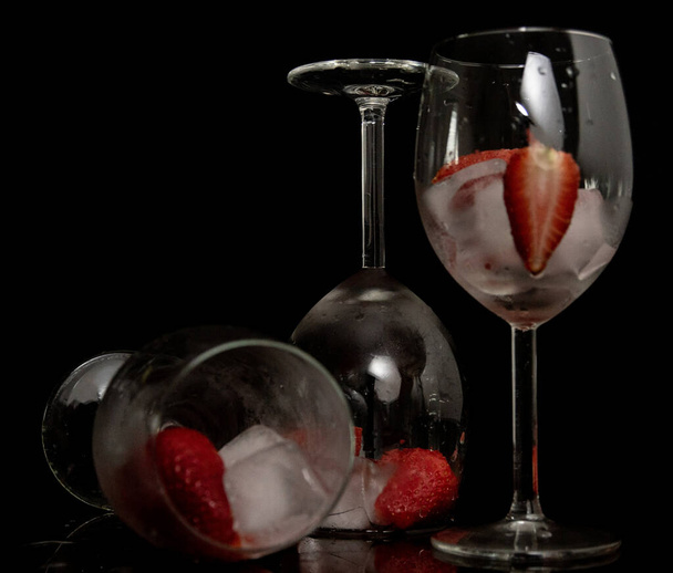 red wine glass with berries and ice isolated on black background - Zdjęcie, obraz