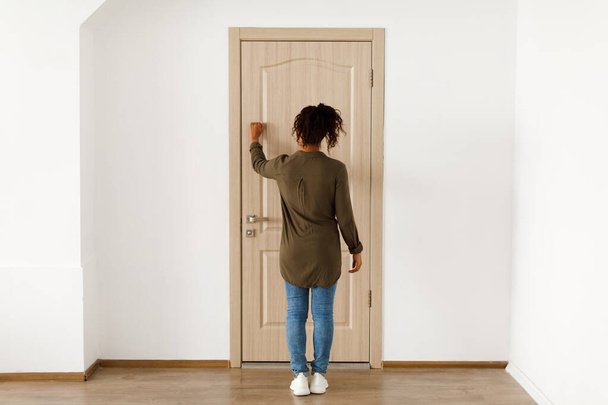 Nerozpoznatelná afroamerická žena klepání na dveře, zadní pohled - Fotografie, Obrázek