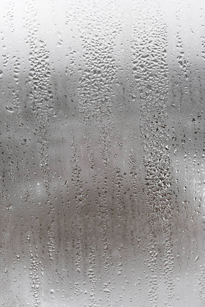 Kondenzáció üveg cseppek folyik lefelé, Függőleges természetes háttér, páratartalom és ködös üres. Kint, rossz idő, eső - Fotó, kép