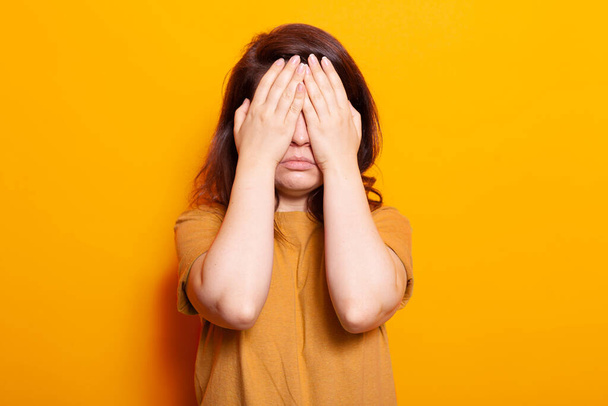 Stressaantunut henkilö peittää kasvot ja silmät käsillään - Valokuva, kuva