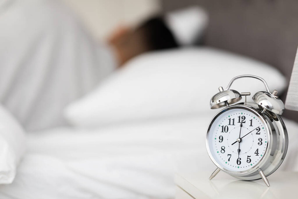 Hora de despertar. Reloj despertador Vintage de pie en la mesita de noche en el dormitorio - Foto, imagen
