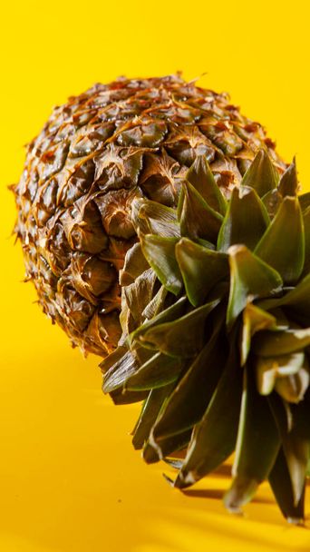 Beautiful fresh pineapple isolated on yellow background. Summer seasonal fruit design idea pattern concept. Copy space, close up - Fotoğraf, Görsel
