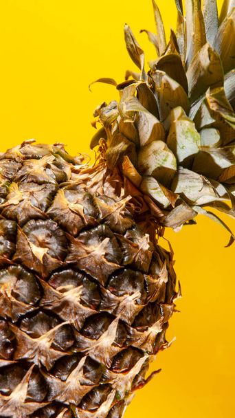 Beautiful fresh pineapple isolated on yellow background. Summer seasonal fruit design idea pattern concept. Copy space, close up - Foto, imagen