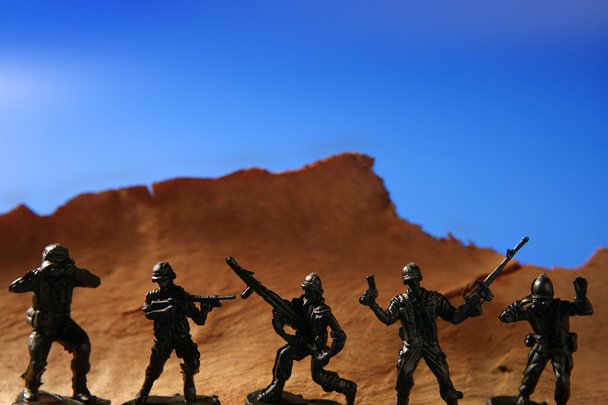 Plastic toy soldier over wooden mountain - Foto, afbeelding