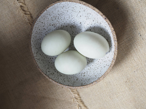 white chicken eggs in a bowl on a wooden background - Fotoğraf, Görsel