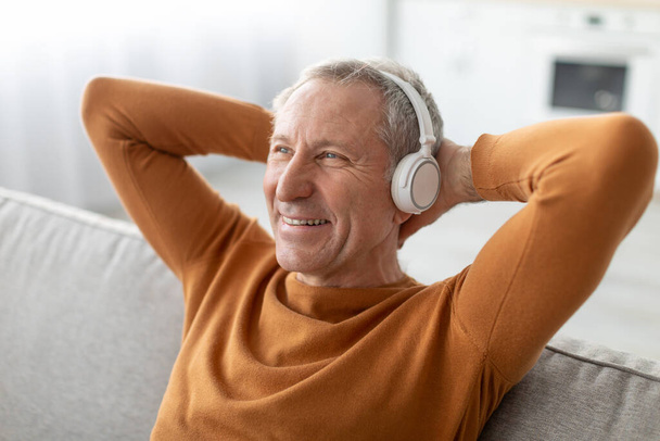 Ruhiger, reifer Mann, der sich zu Hause ausruht und Musik hört - Foto, Bild