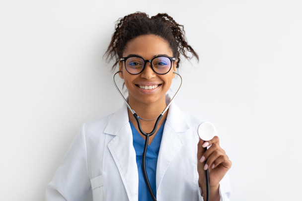 Портрет чорного лікаря, який посміхається і показує стетоскоп
 - Фото, зображення