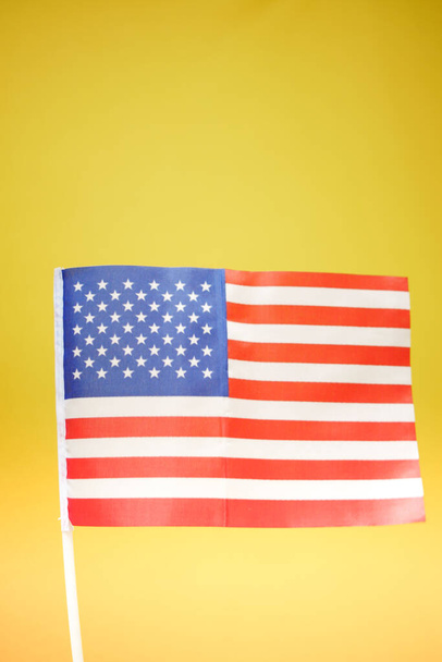 Bandera americana sobre fondo amarillo de cerca  - Foto, imagen