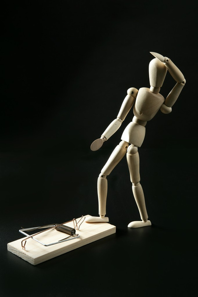 Wooden mannequin with mouse trap, black background - Фото, зображення