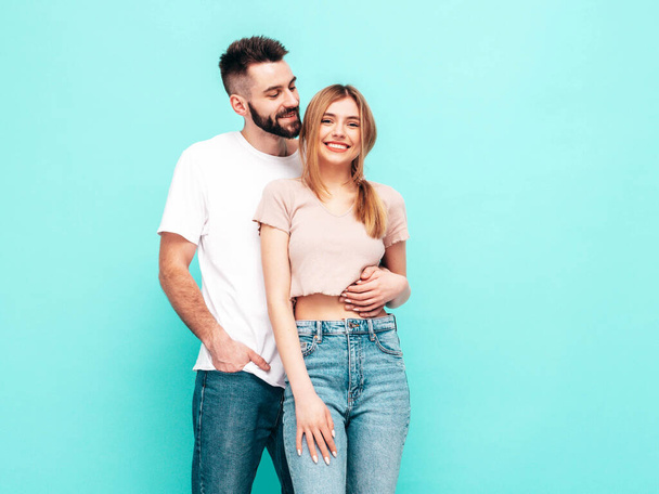 Sexy smiling beautiful woman and her handsome boyfriend. Happy cheerful family having tender moments near blue wall in studio.Pure cheerful models hugging.Embracing each other. Cheerful and happy - Φωτογραφία, εικόνα