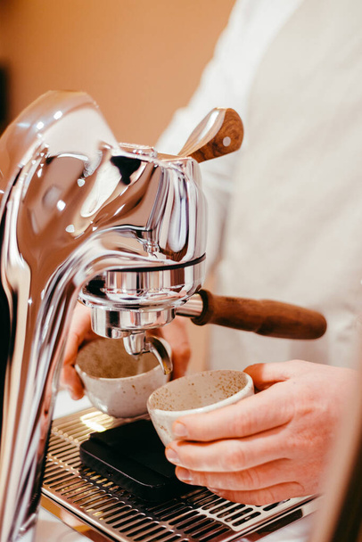 barista pouring coffee into a cup with a grinder - Foto, Bild