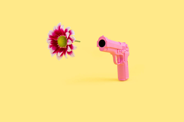 pink watering can with a gun on a yellow background - Foto, Bild