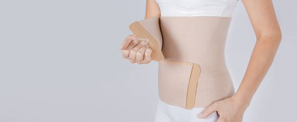 Lumbar brace on the human body isolated on a white background. Trauma of back. Back brace, orthopedic lumbar, support belt for back muscles. Lower back problems health - Foto, imagen