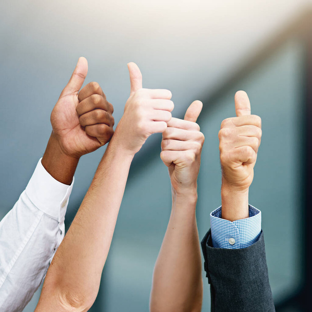 You did it. Closeup shot of a group of businesspeople showing thumbs up in an office. - Fotografie, Obrázek