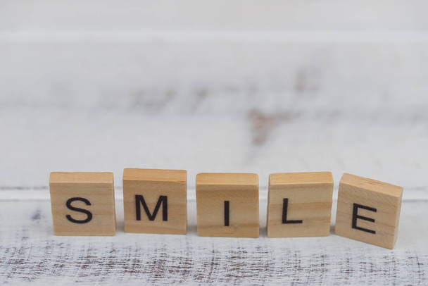 Alfabeto sonrisa palabra sobre blanco viejo vintage madera fondo - Foto, Imagen