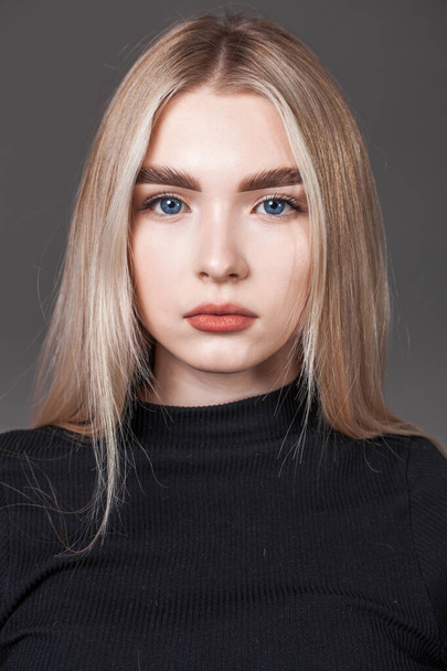 Portrait of a young blonde girl on dark background - Foto, Imagem