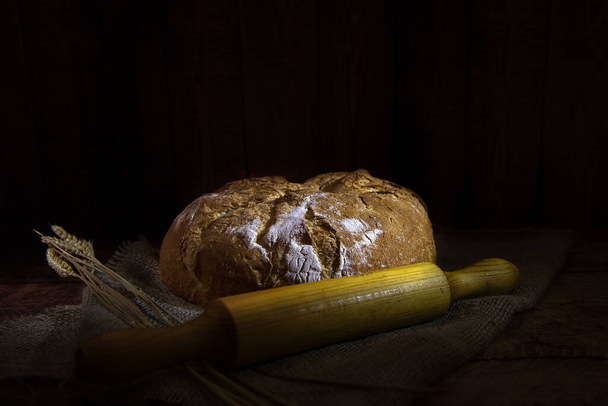 bread and wheat on a dark background - Fotografie, Obrázek