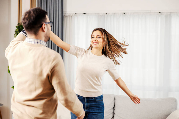 A happy couple dancing together at their new cozy home. - Foto, Bild