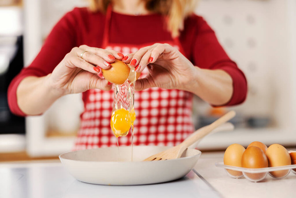 Gros plan d'une femme au foyer faisant un côté ensoleillé œufs à sa maison. - Photo, image