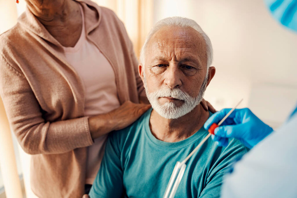 Un uomo anziano sottoposto a test sul virus coronarico con tampone di cotone / PCR. Prevenzione, diagnosi e test delle malattie. - Foto, immagini