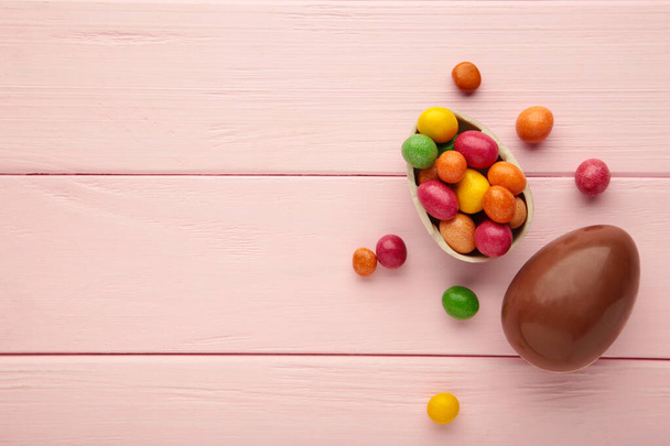 Chocolate easter eggs on wooden pink background. Top view - 写真・画像