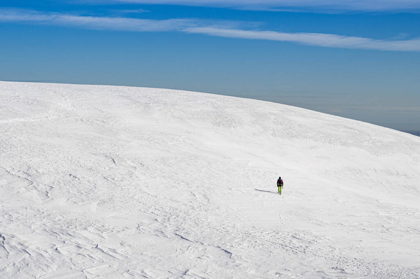 man in a ski suit with a backpack on the background of the mountains. - Fotó, kép