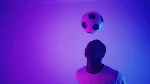 hombre negro está jugando con pelota de fútbol en el estudio, entrenamiento keepie uppie, futbolista profesional - Metraje, vídeo
